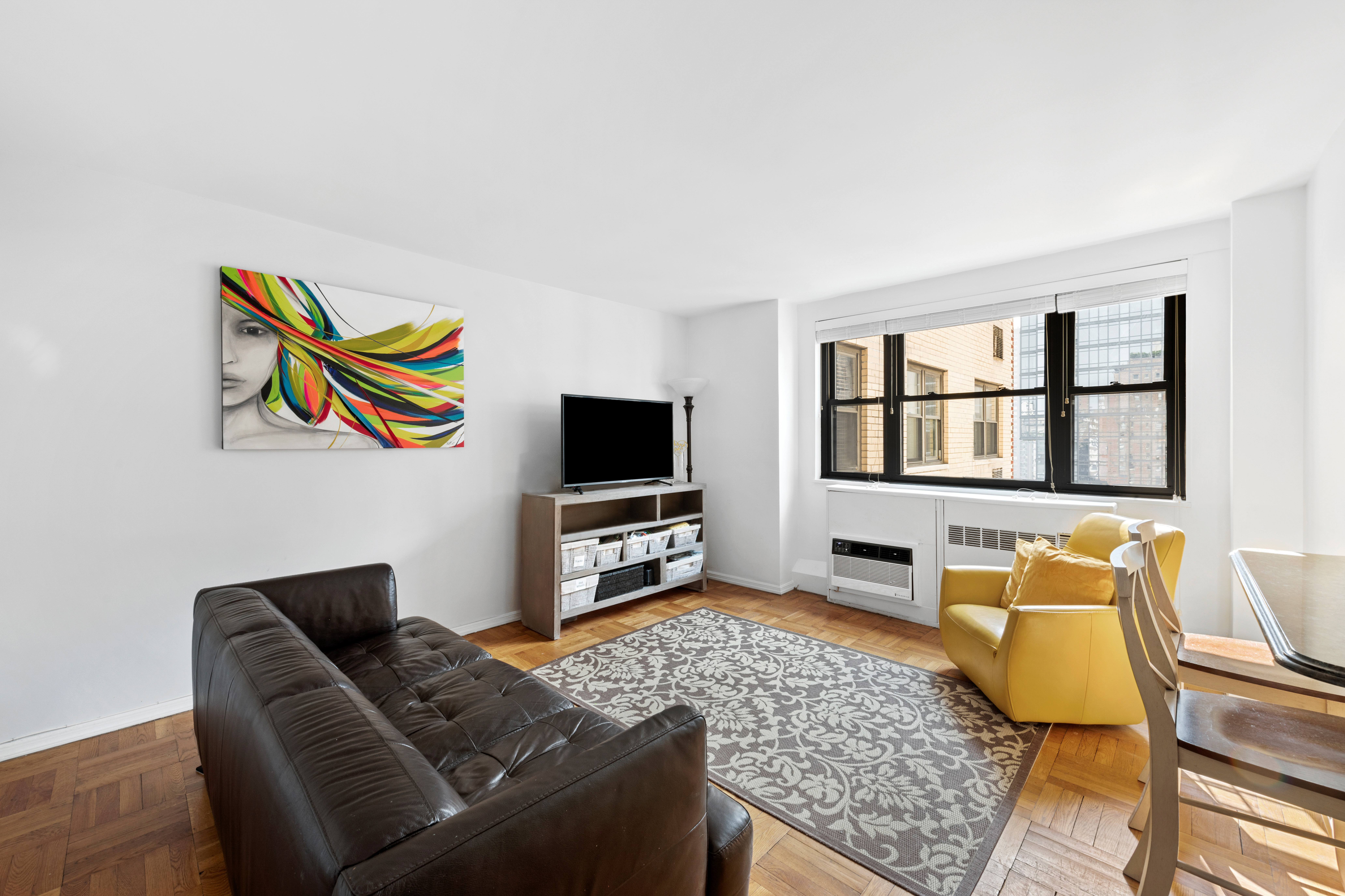 315 East 72nd Street, Unit 15M Manhattan, NY 10021 - Photo 2 of 18 a living room with furniture and a flat screen tv