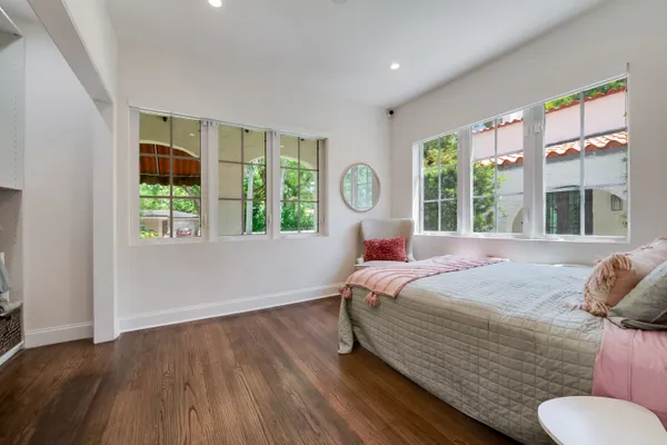 a bedroom with a bed and a large window