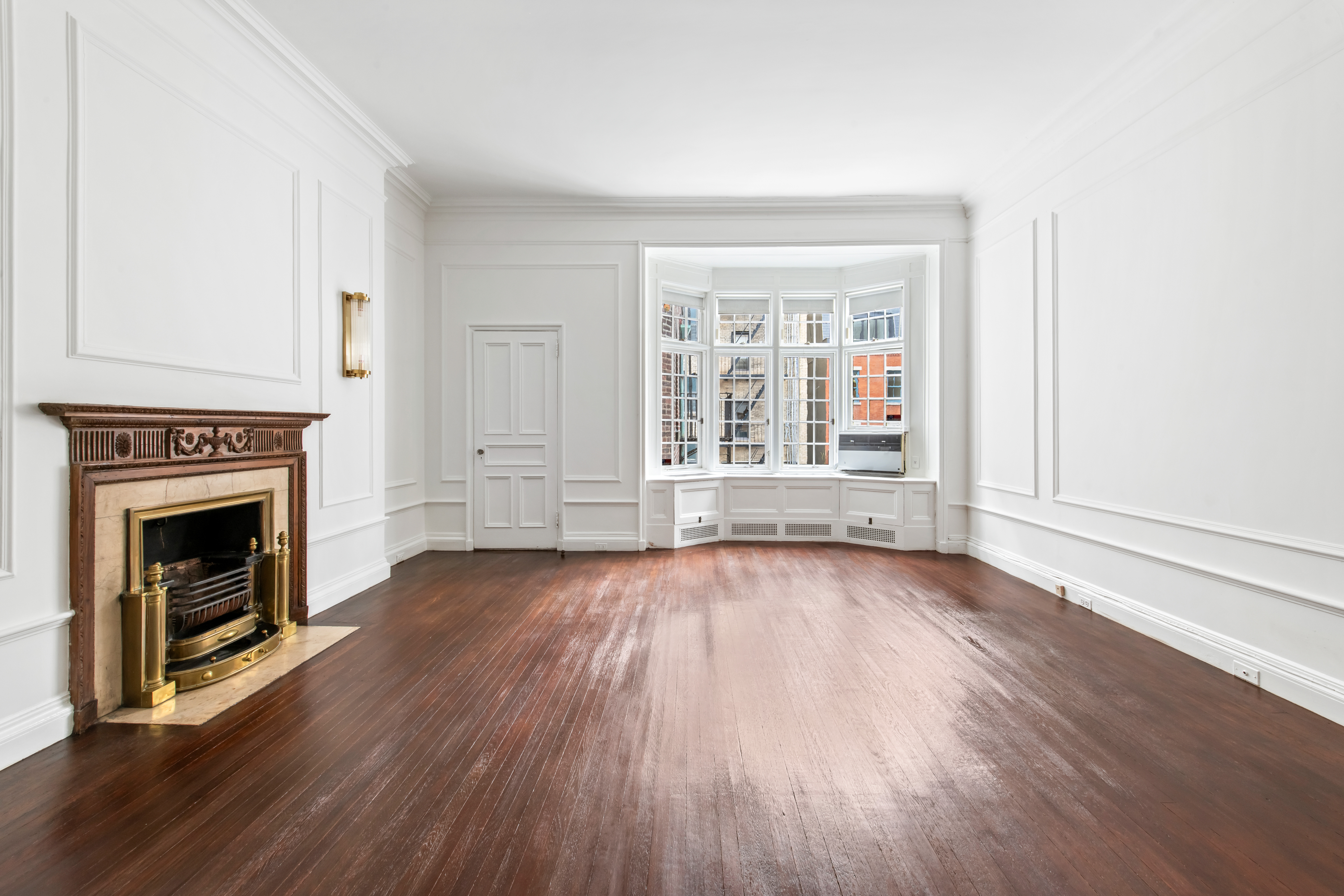 155 East 70th Street Manhattan, NY 10021 - Photo 13 of 27 an empty room with wooden floor fireplace and windows