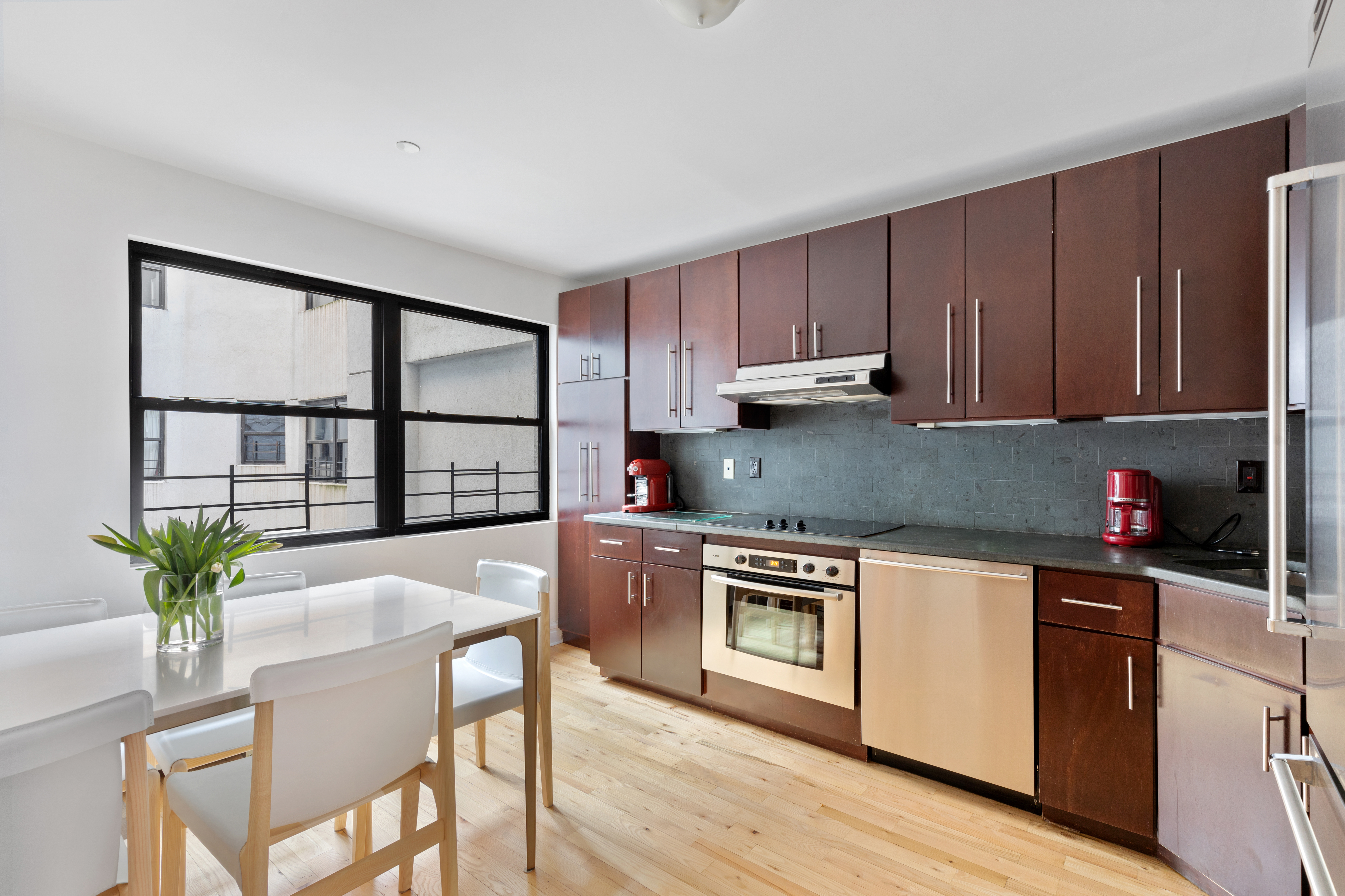 79 Laight Street, Unit 5H Manhattan, NY 10013 - Photo 5 of 13 a kitchen with stainless steel appliances granite countertop a stove a sink a microwave and a refrigerator