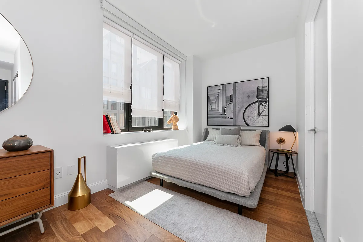 42-14 Crescent Street, Unit 9D Queens, NY 11101 - Photo 2 of 6 a bedroom with a bed and a dresser