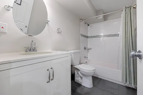 a bathroom with a granite countertop sink toilet and shower