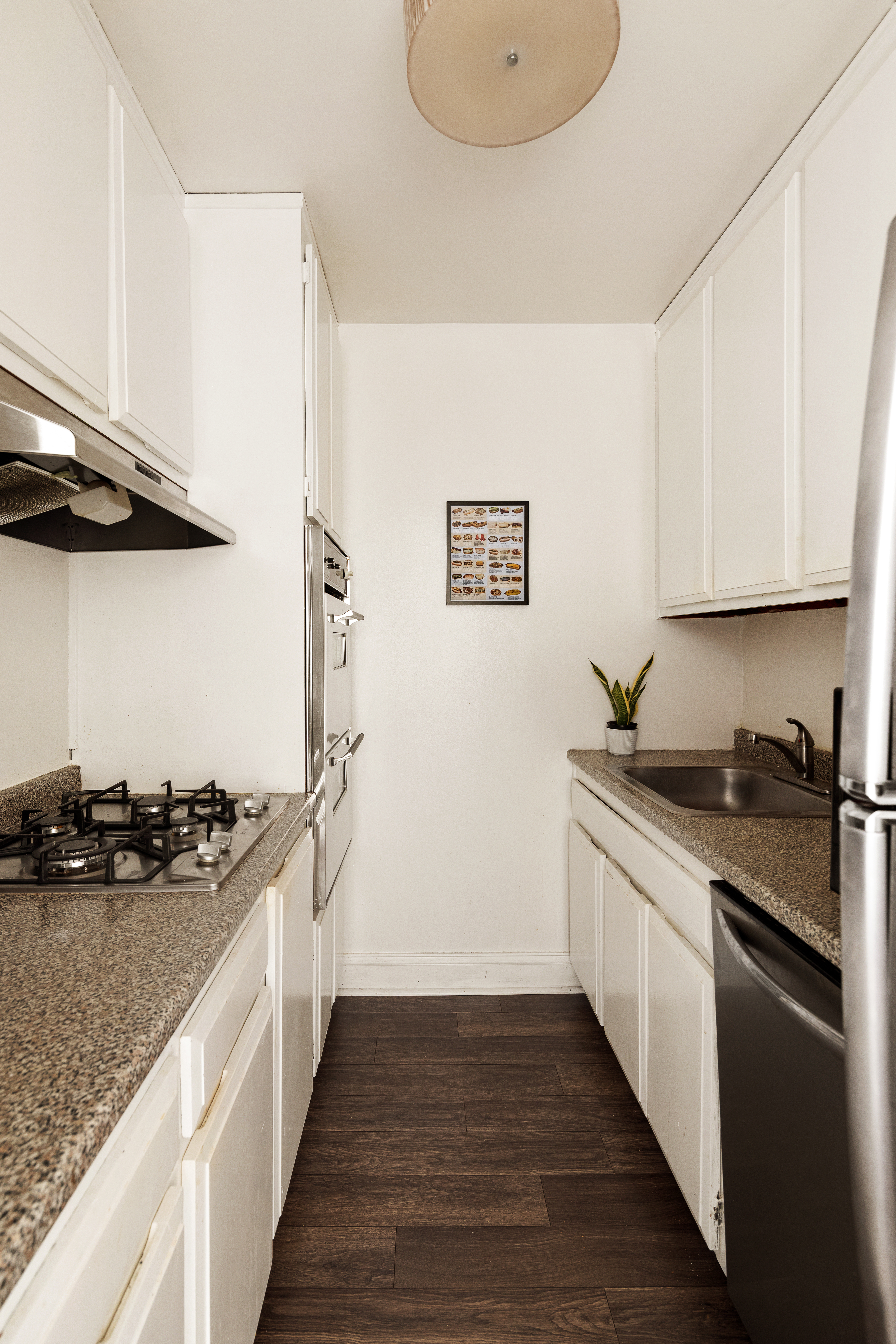 7 East 14th Street, Unit 1115 Manhattan, NY 10003 - Photo 4 of 6 a kitchen with stainless steel appliances granite countertop a sink stove and refrigerator