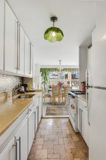 a kitchen with stainless steel appliances granite countertop a sink a stove oven a counter space and cabinets