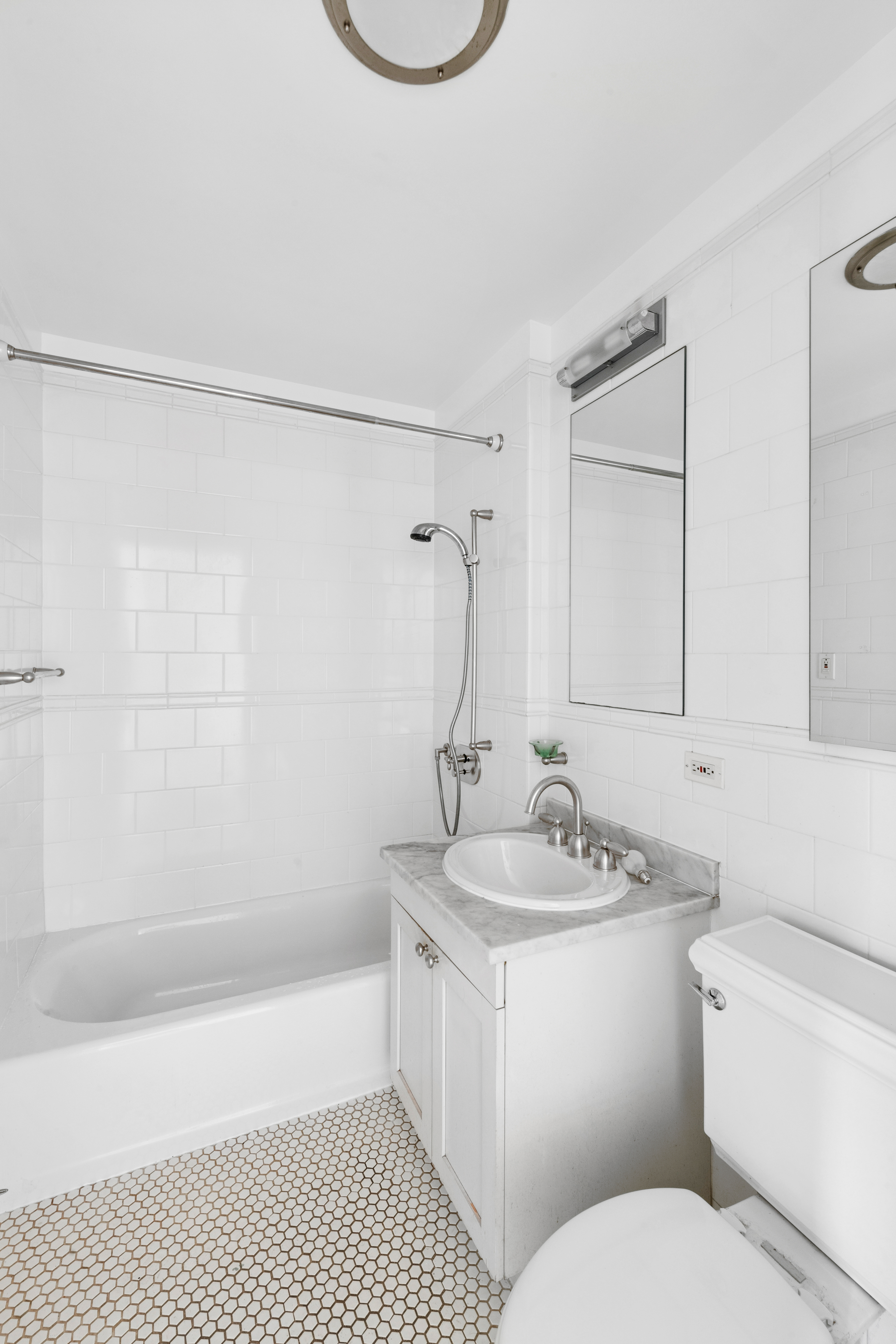 425 5th Avenue, Unit 23D Manhattan, NY 10016 - Photo 11 of 20 a bathroom with a sink toilet a shower and bathtub