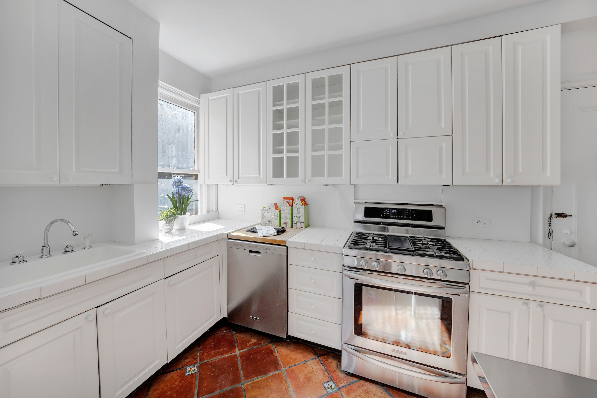 51 East 90th Street, Unit 8D Manhattan, NY 10128 - Photo 5 of 10 a kitchen with cabinets appliances a sink and a window