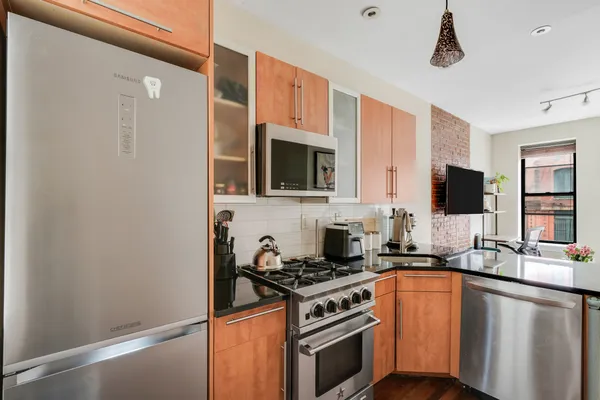 a kitchen with stainless steel appliances granite countertop a stove a sink and a microwave