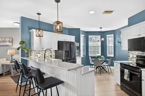 a view of kitchen with sink dining table and chairs