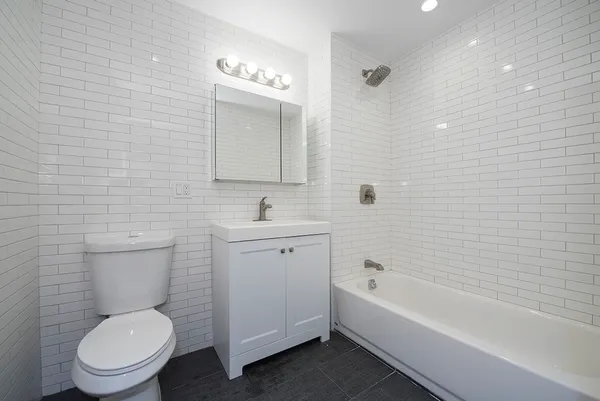 a bathroom with a toilet a sink a mirror and bathtub