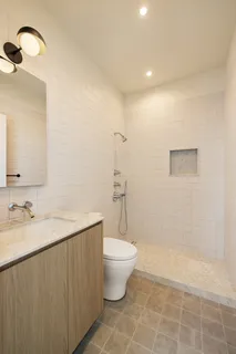 a bathroom with a granite countertop sink a toilet and a mirror
