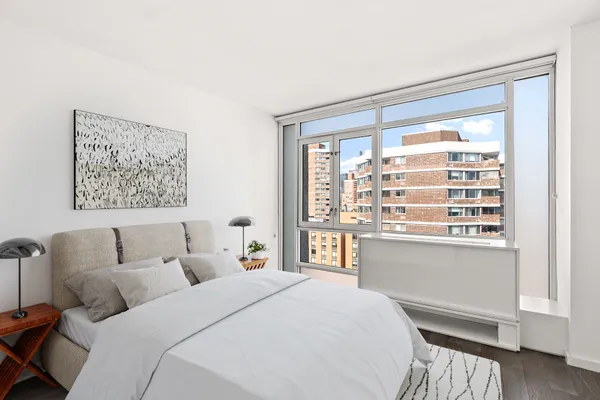 a bedroom with bed and a large window