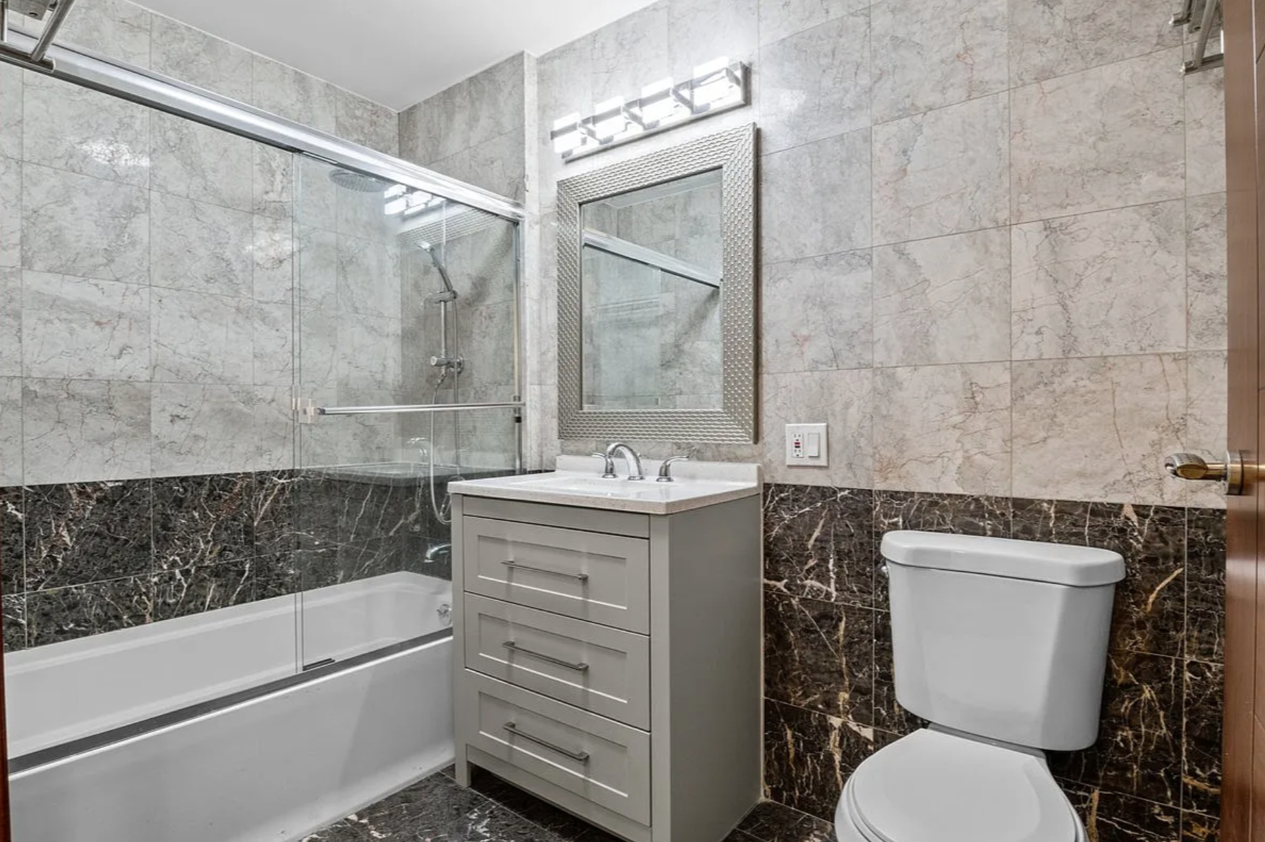 2882 West 15th Street, Unit 2B Brooklyn, NY 11224 - Photo 8 of 13 a bathroom with a sink toilet vanity and shower