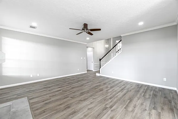 wooden floor in an empty room with a ceiling fan