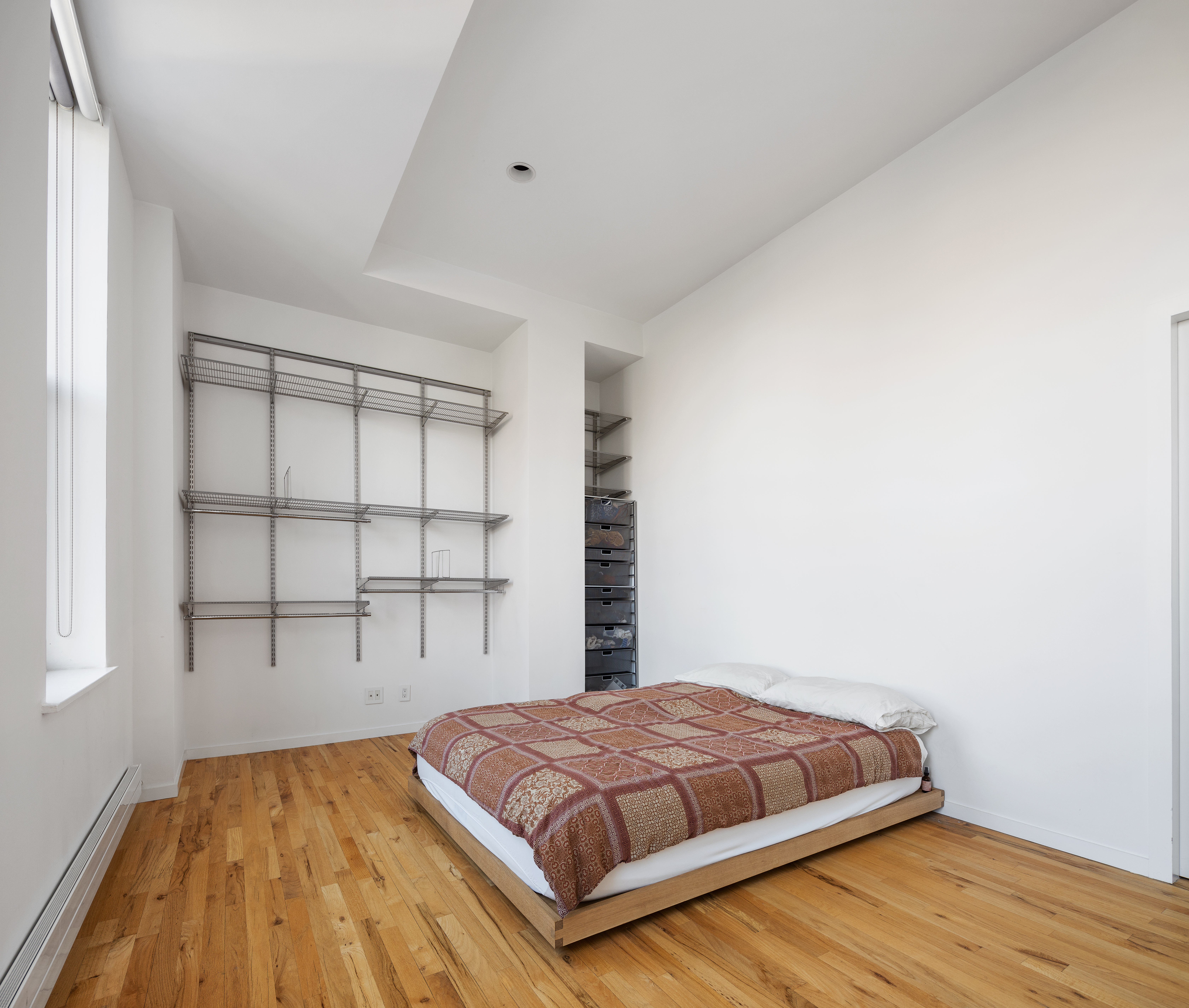 175 East Broadway, Unit 6D Manhattan, NY 10002 - Photo 9 of 18 a bedroom with a bed and window