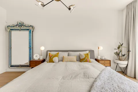 a bedroom with a bed and wooden floor