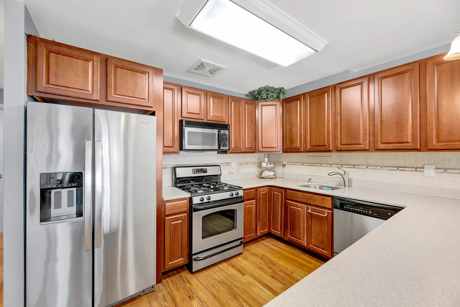 a kitchen with stainless steel appliances granite countertop a refrigerator stove and sink