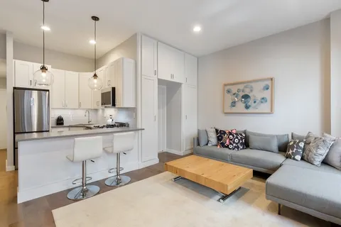 a living room with furniture and kitchen view