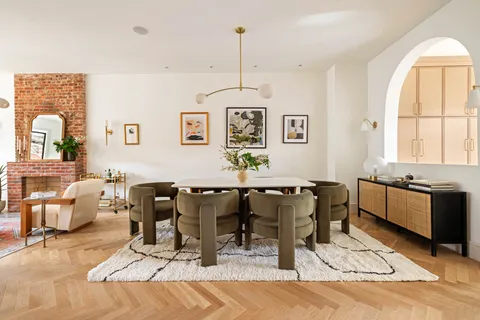 a living room with furniture two window and wooden floor