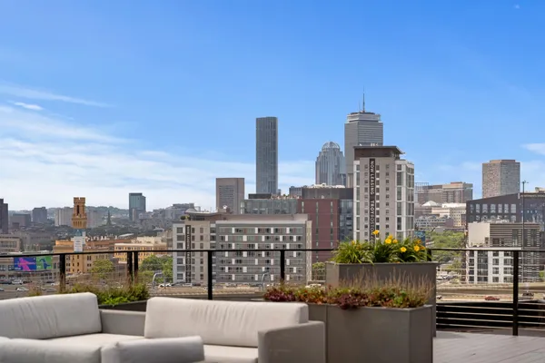 a view of roof deck with a couple of cars parked in front of it