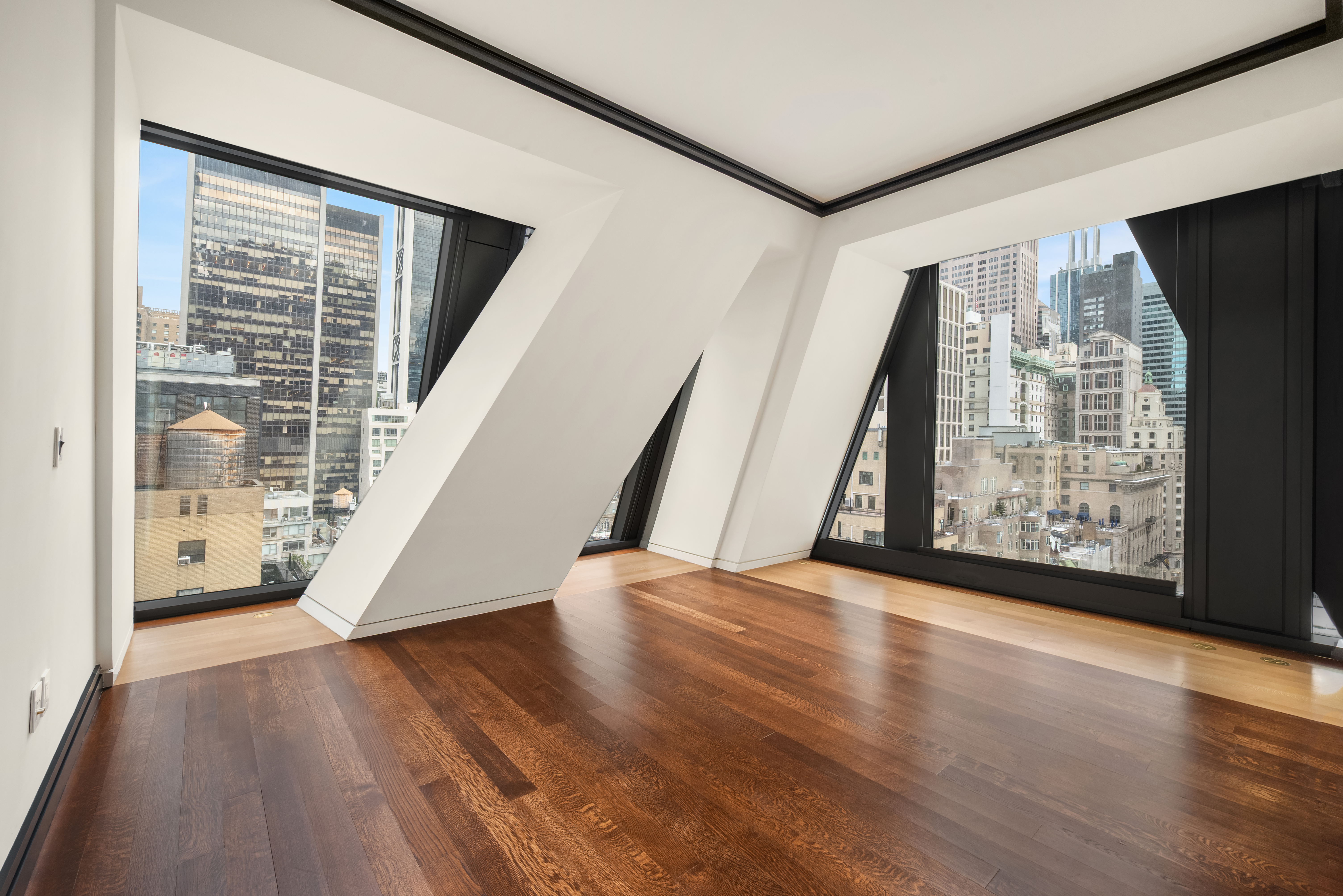 53 West 53rd Street, Unit 16C Manhattan, NY 10019 - Photo 3 of 12 a view of an empty room with wooden floor and a window