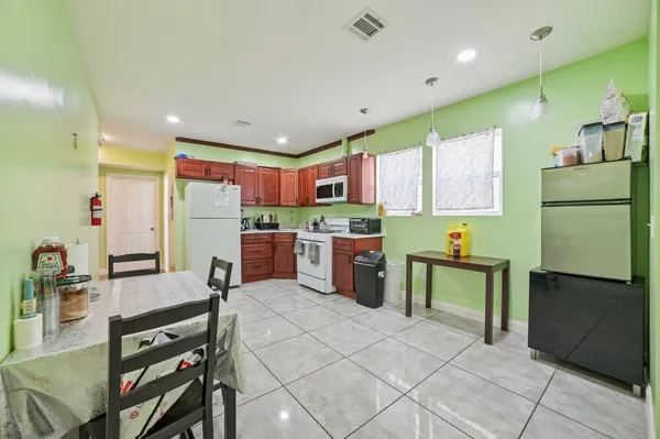 a kitchen with stainless steel appliances kitchen island granite countertop a refrigerator and a stove top oven