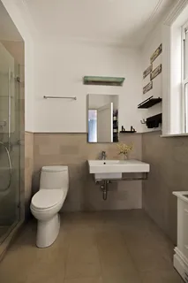 a bathroom with a toilet sink and mirror