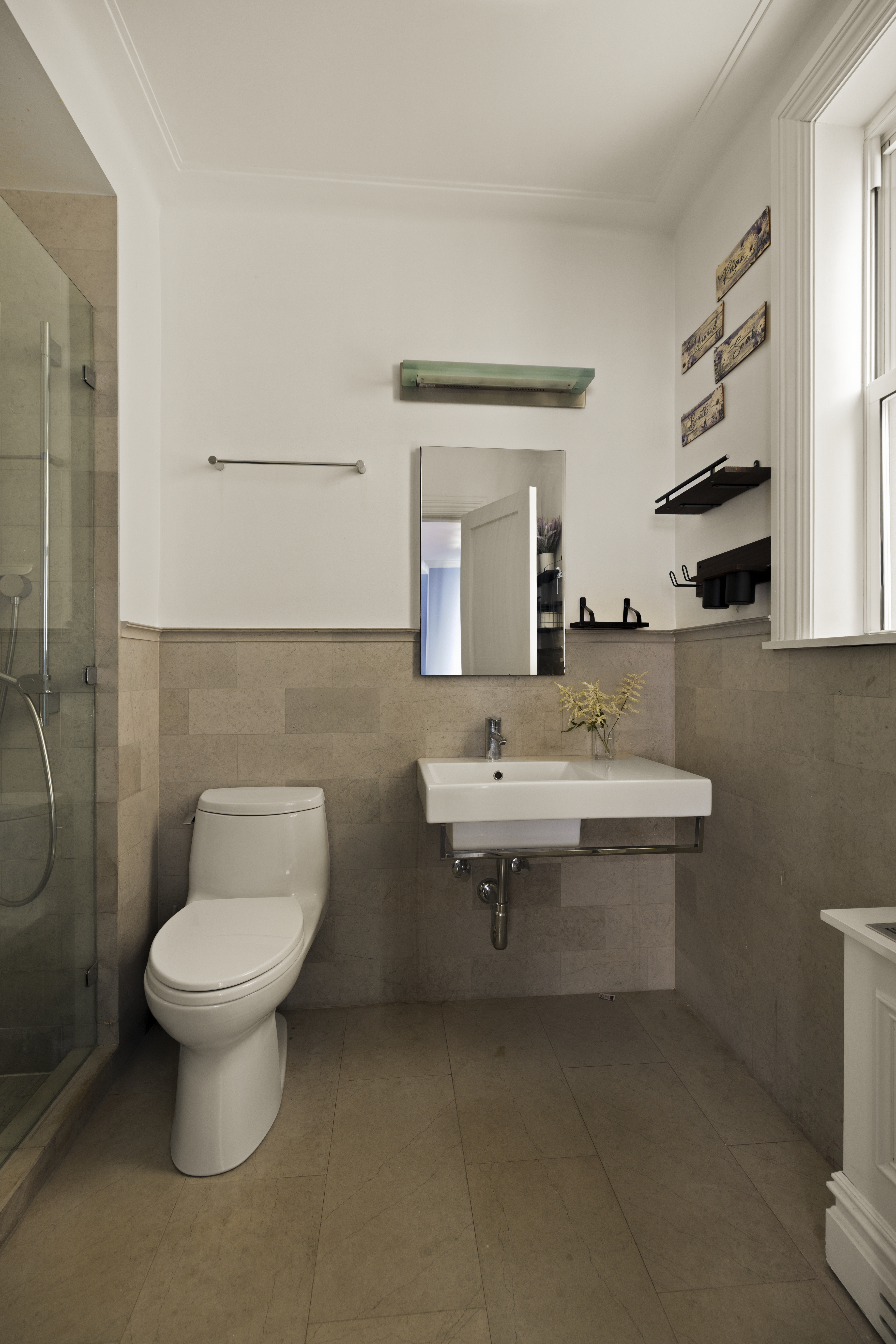 1158 5th Avenue, Unit 4A Manhattan, NY 10128 - Photo 13 of 23 a bathroom with a toilet sink and mirror