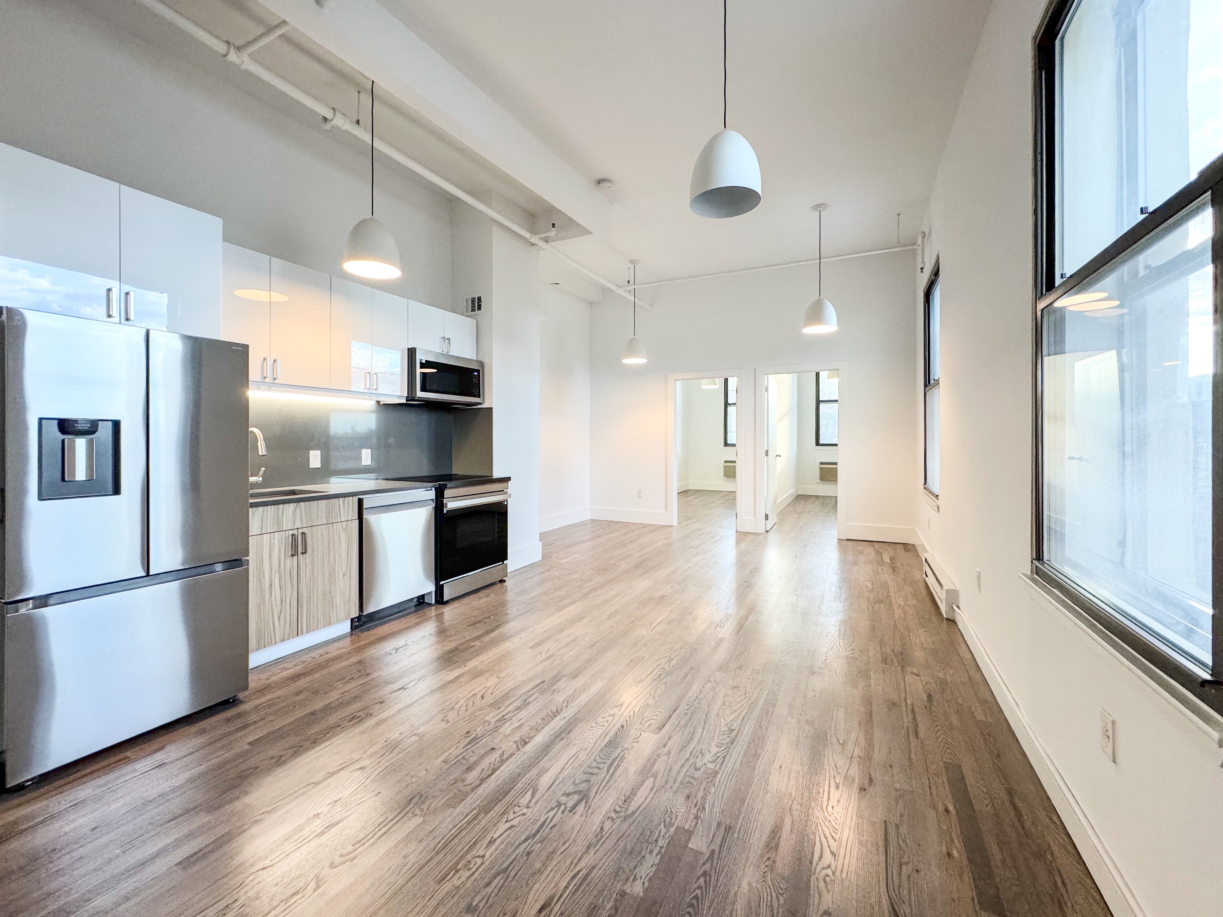 44 Berry Street, Unit 4J Brooklyn, NY 11249 - Photo 1 of 8 a kitchen with stainless steel appliances a refrigerator sink and cabinets