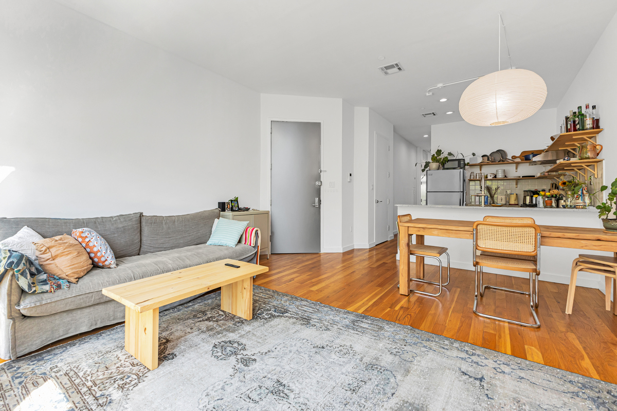 a living room with furniture a rug and kitchen view
