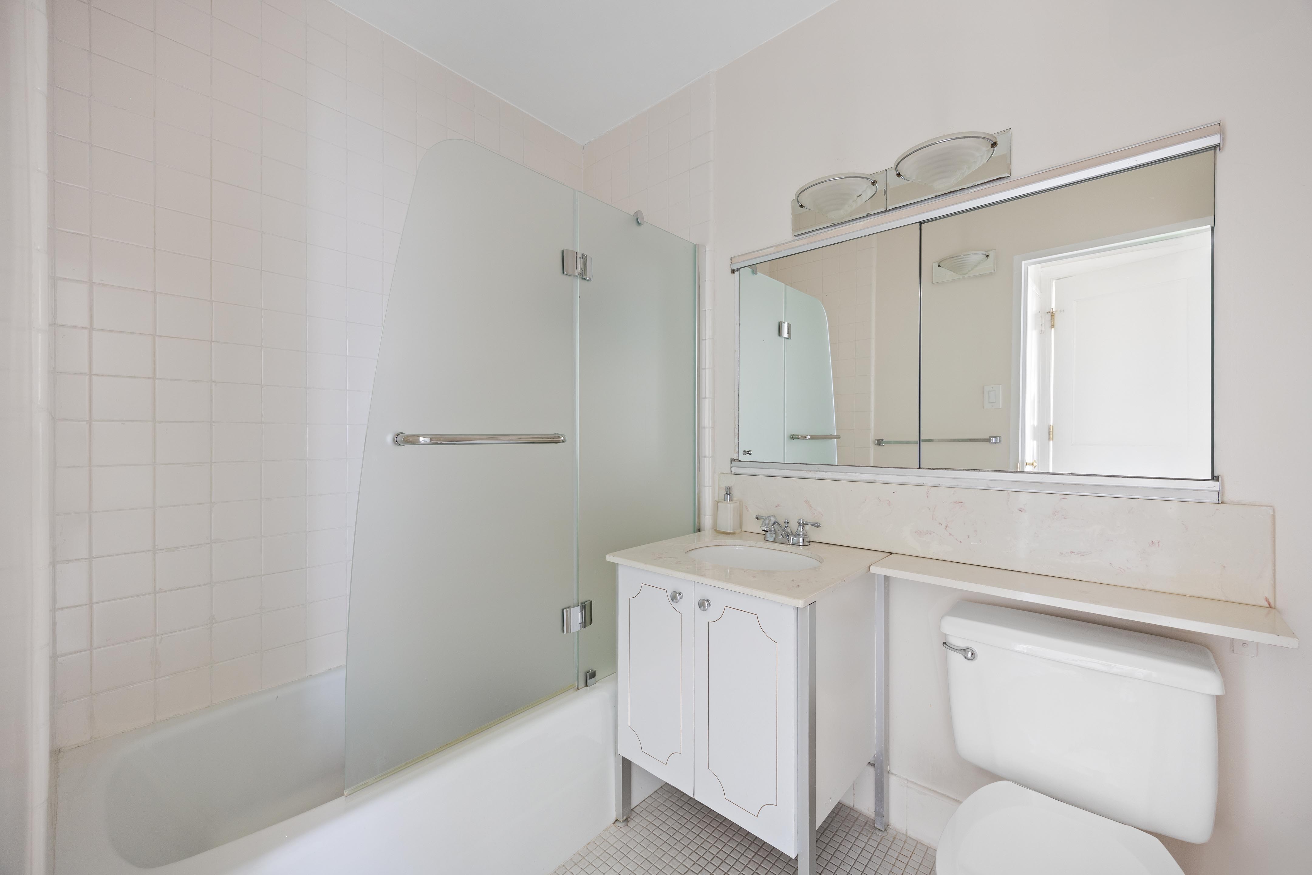 159 West 53rd Street, Unit 16E Manhattan, NY 10019 - Photo 7 of 10 a bathroom with a sink a toilet and shower