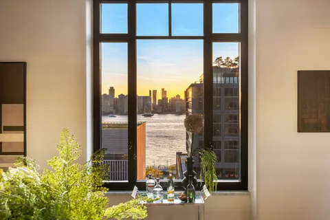 a view of a room with a floor to ceiling window and wooden floor