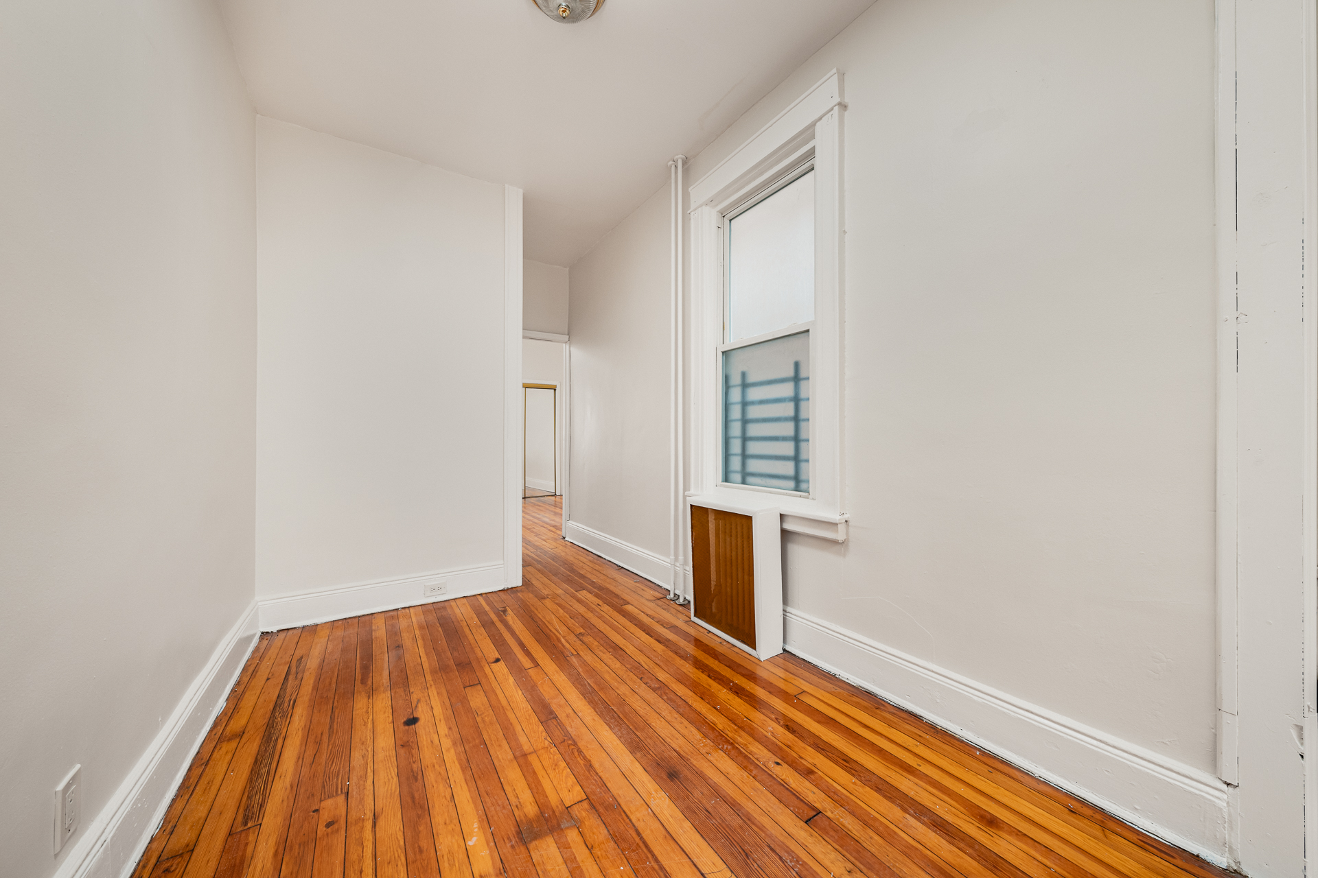 70-03 66th Street, Unit 1L Queens, NY 11385 - Photo 6 of 8 a view of empty room with wooden floor