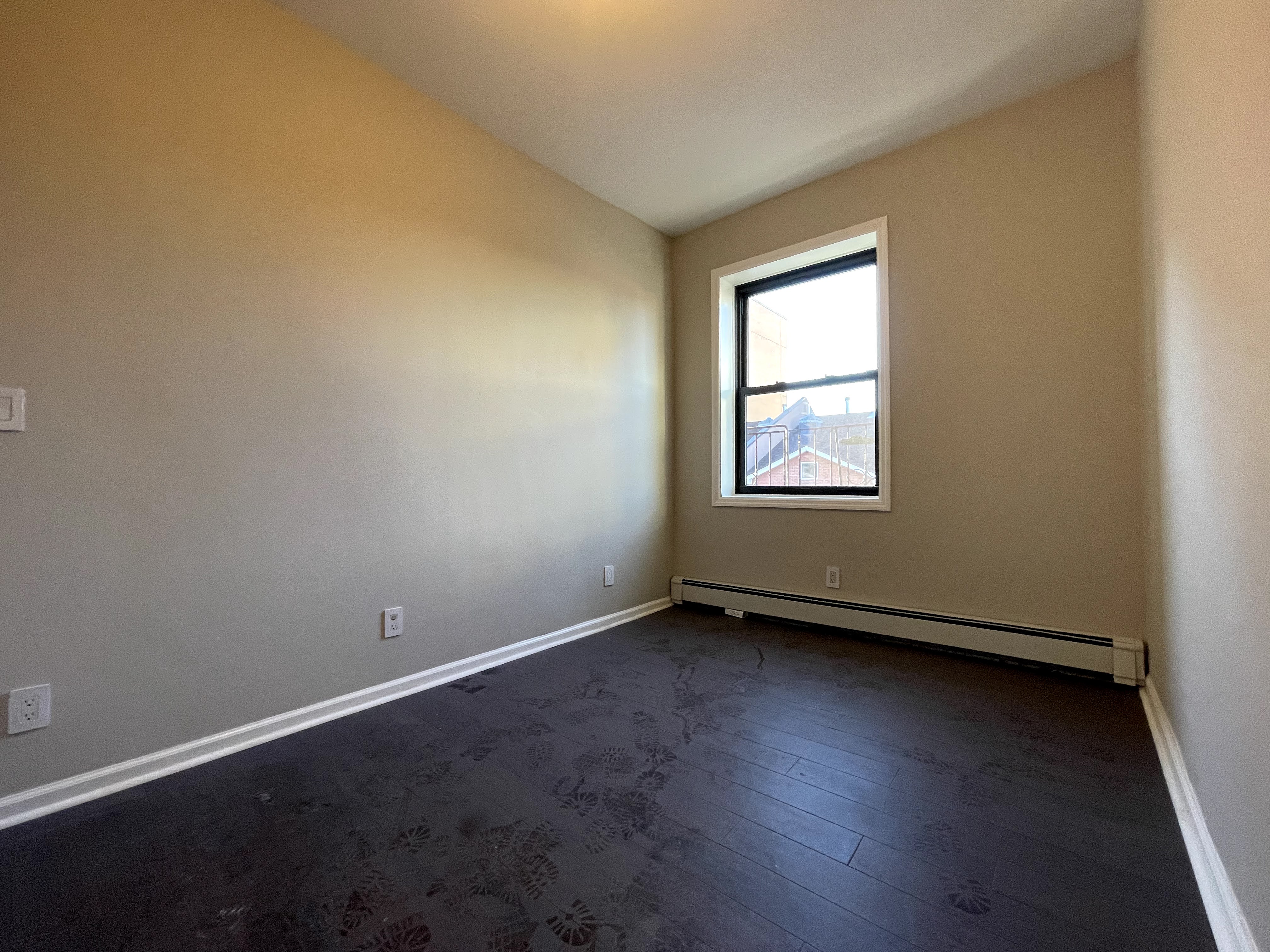 350 Irving Avenue, Unit 2F Brooklyn, NY 11237 - Photo 3 of 5 an empty room with wooden floor and windows