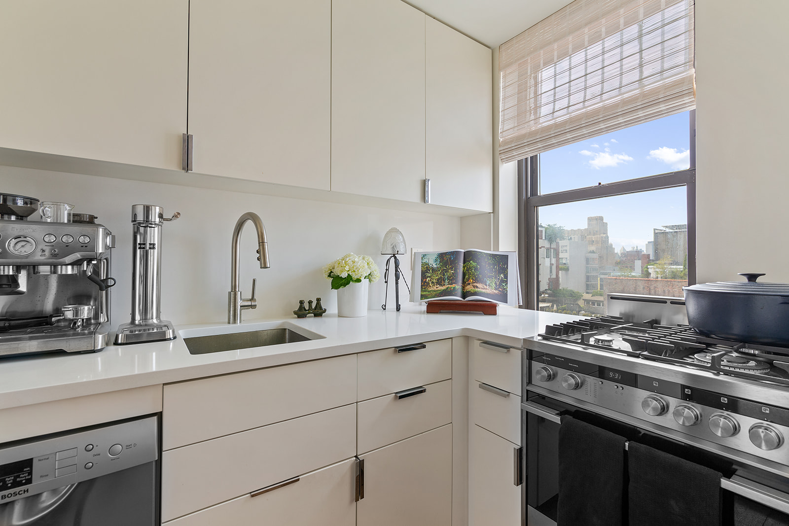 161 West 16th Street, Unit 12D Manhattan, NY 10011 - Photo 5 of 8 a kitchen with stainless steel appliances granite countertop a sink stove and white cabinets