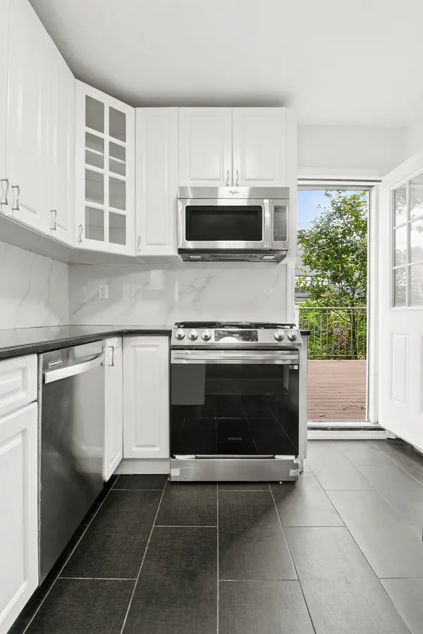 a kitchen with granite countertop a stove a microwave and cabinets