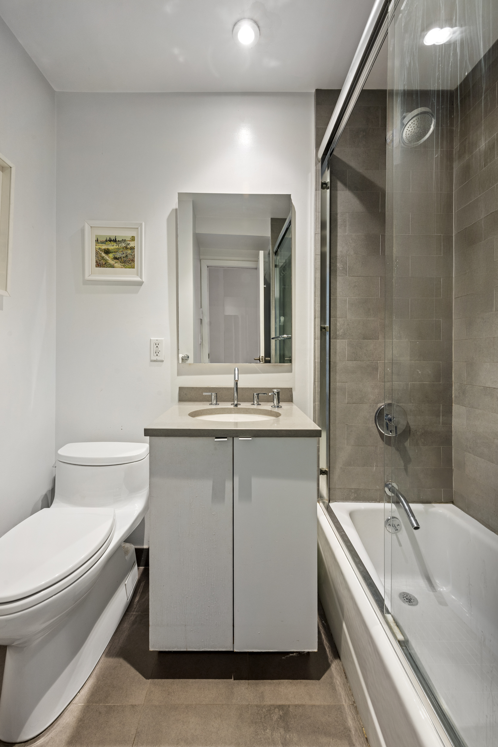 121 Morton Street, Unit 2A Manhattan, NY 10014 - Photo 8 of 9 a bathroom with a granite countertop sink a toilet and shower