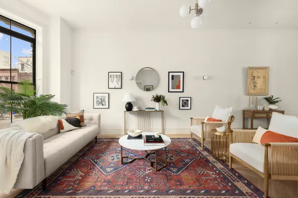 a living room with furniture a rug and a window