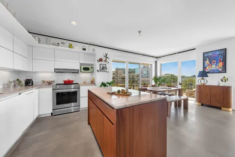 a kitchen with kitchen island a stove a sink and a refrigerator