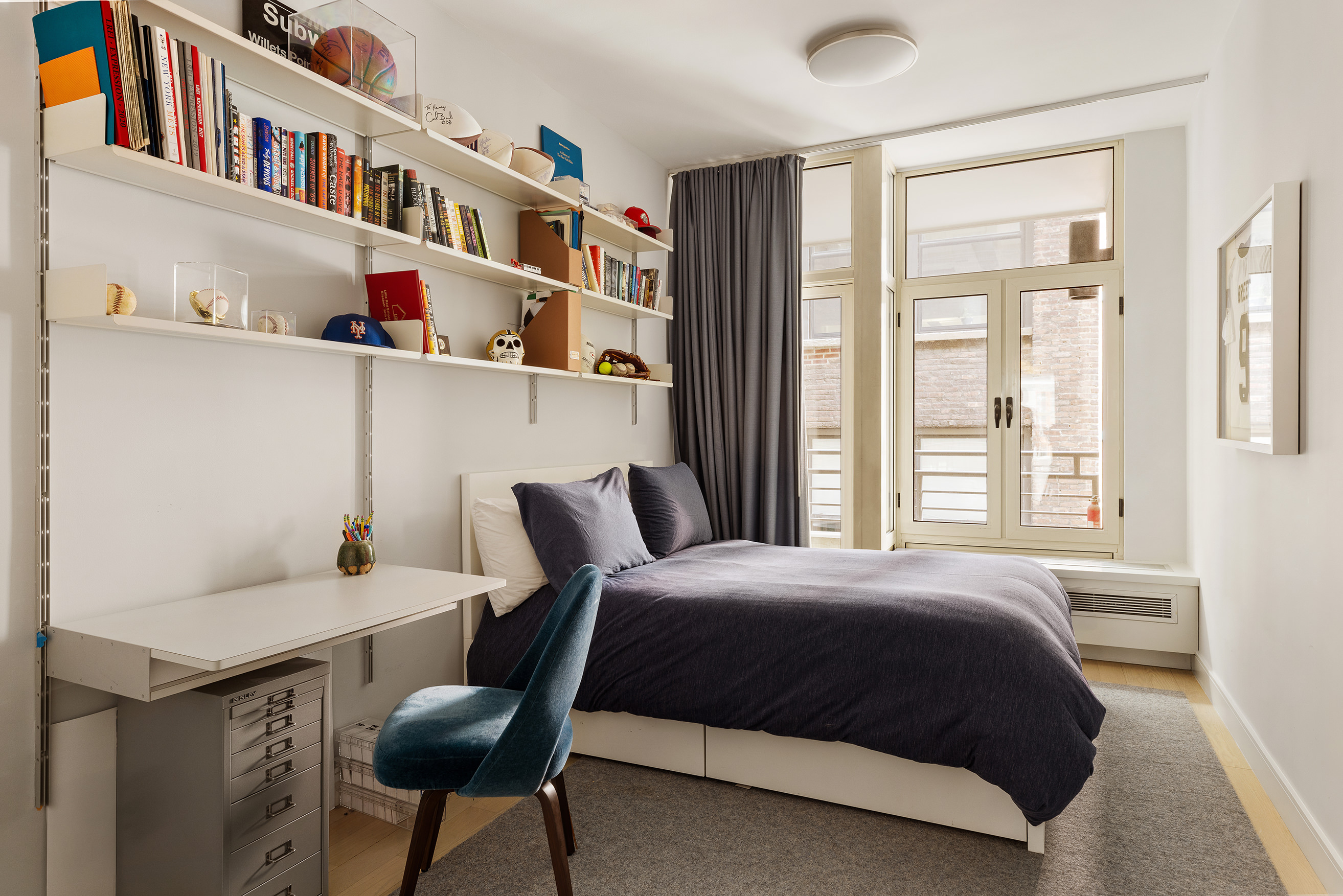 129 West 20th Street, Unit 4B Manhattan, NY 10011 - Photo 14 of 16 a bedroom with a bed and a bookshelf