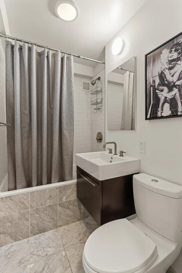 a bathroom with a toilet a sink and a mirror