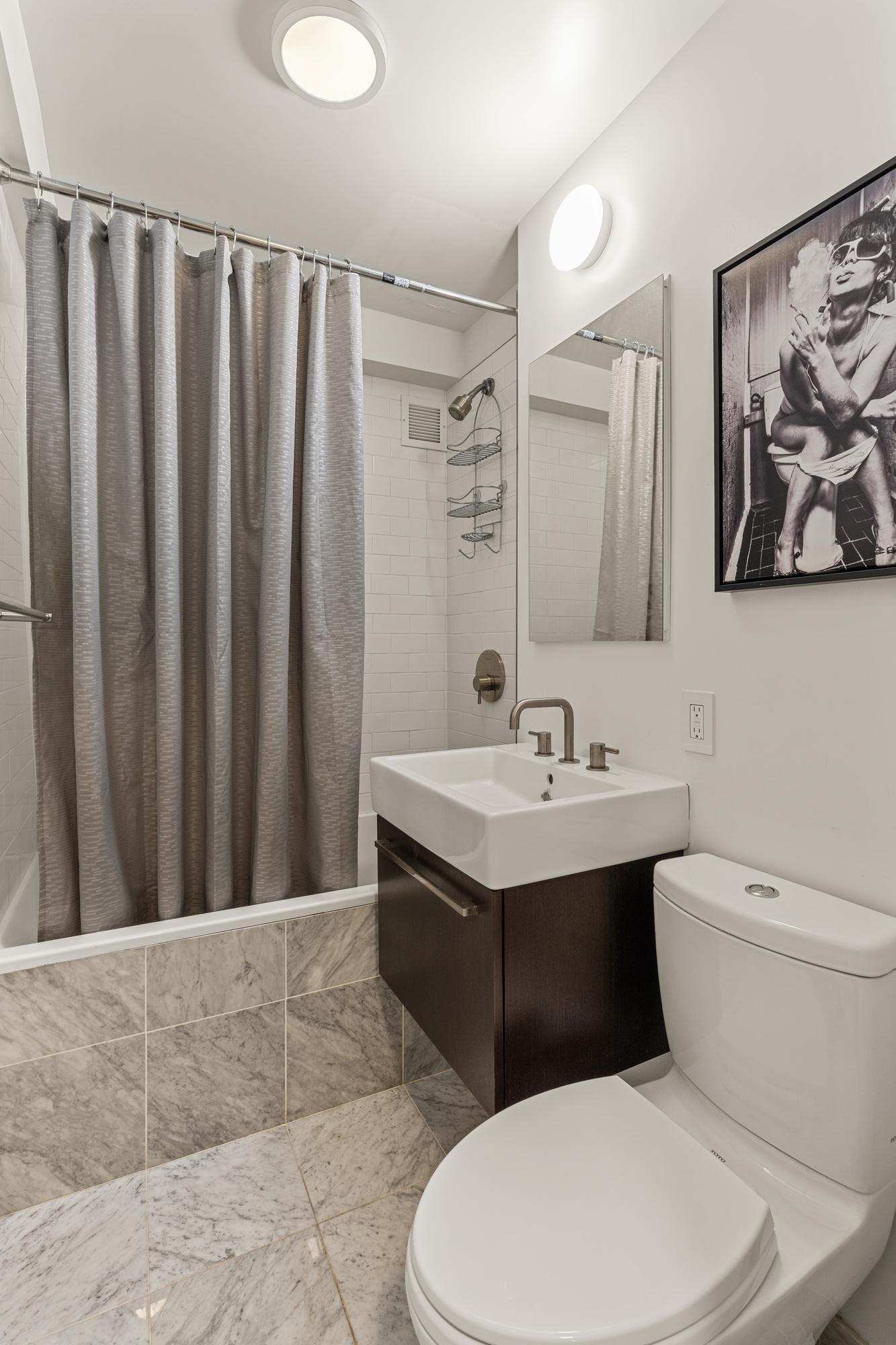 425 East 63rd Street, Unit W6A Manhattan, NY 10065 - Photo 6 of 11 a bathroom with a toilet a sink and a mirror