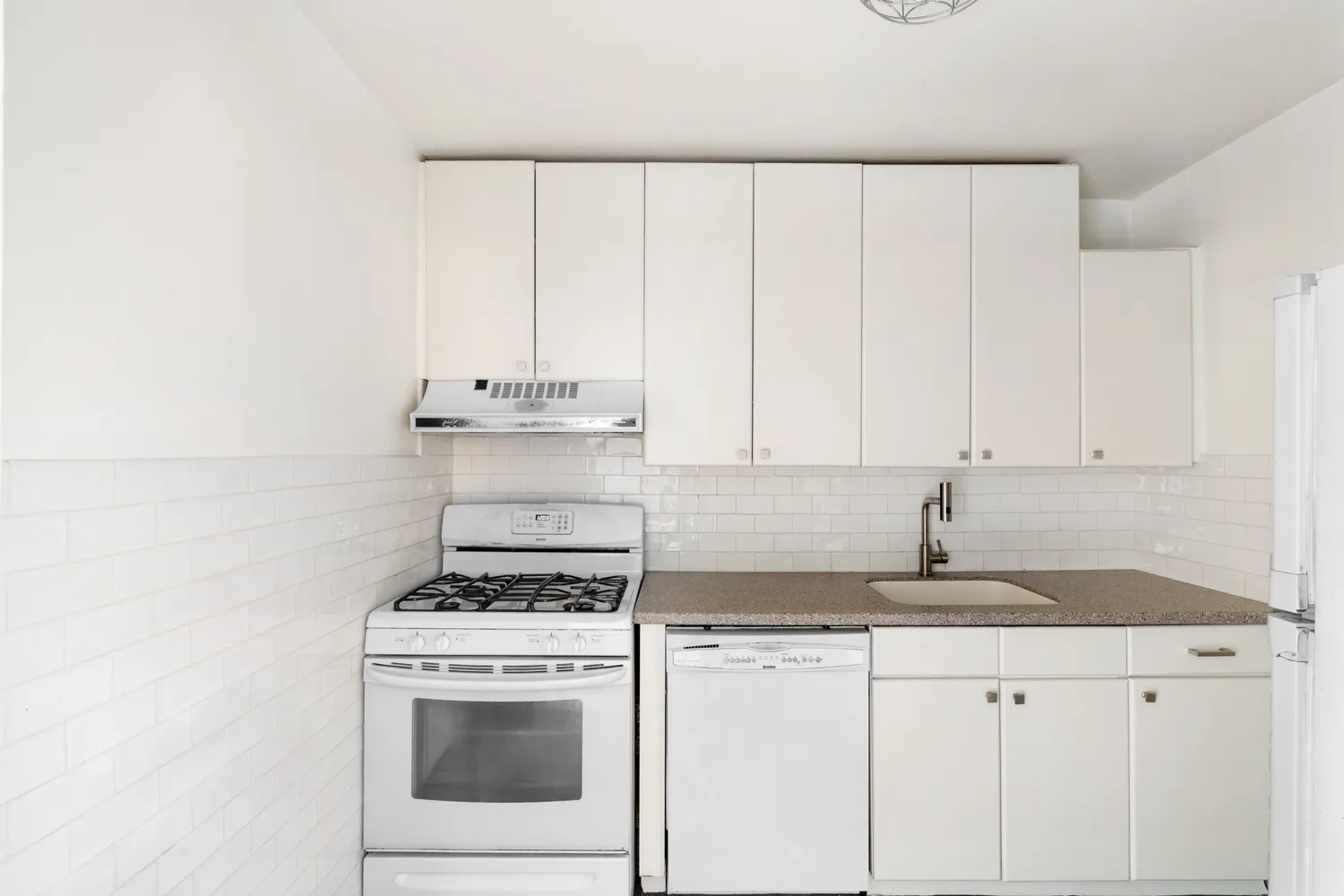 a kitchen with granite countertop white cabinets and white appliances