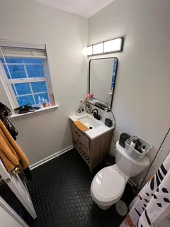 a bathroom with a toilet sink and mirror
