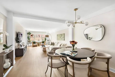 a dining room with furniture a chandelier and wooden floor