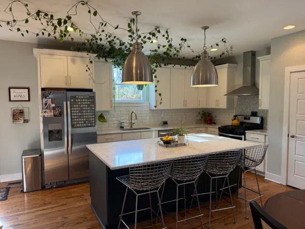 a kitchen with granite countertop a table chairs stove and cabinets