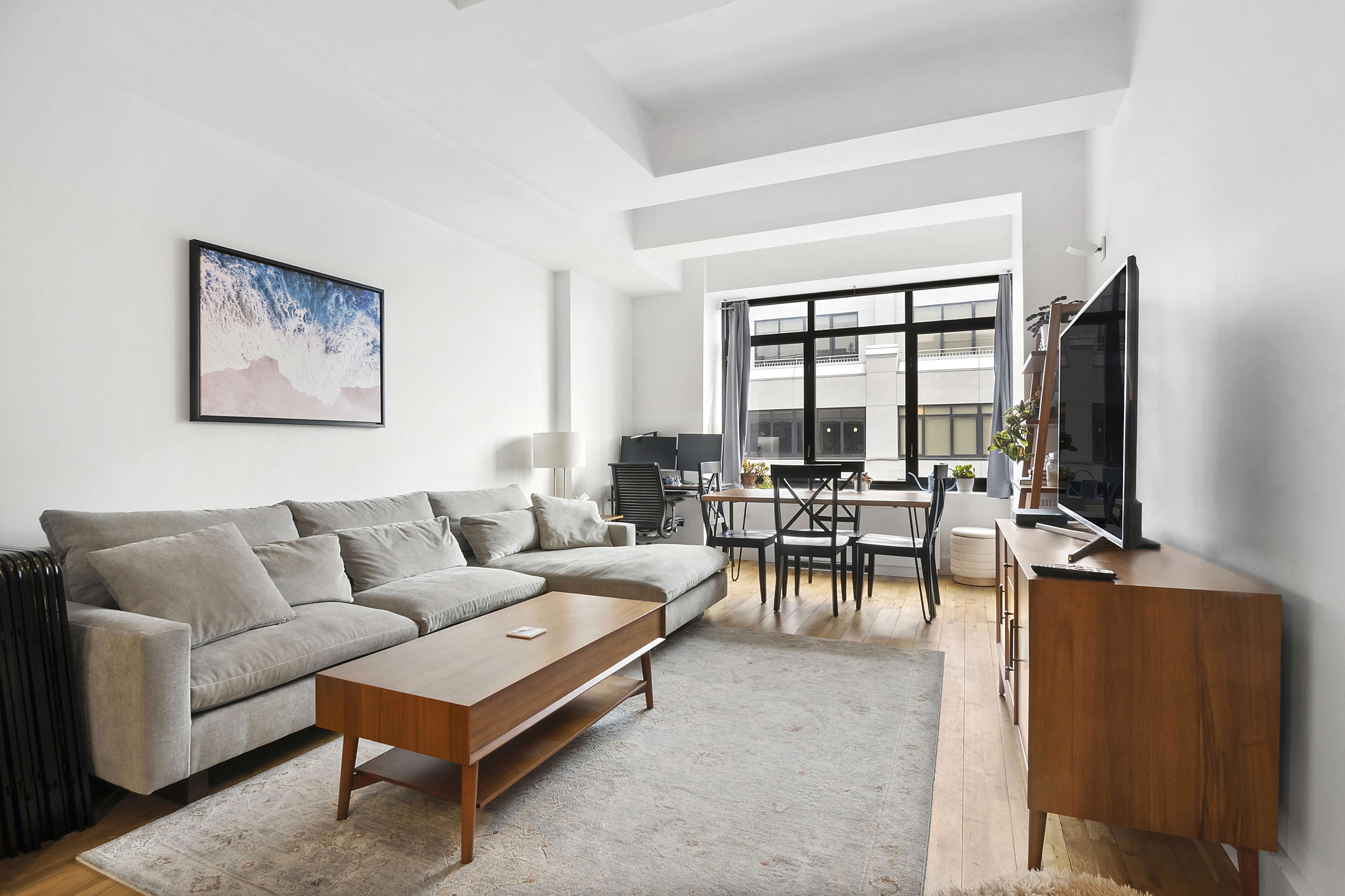 a living room with furniture a flat screen tv and a large window