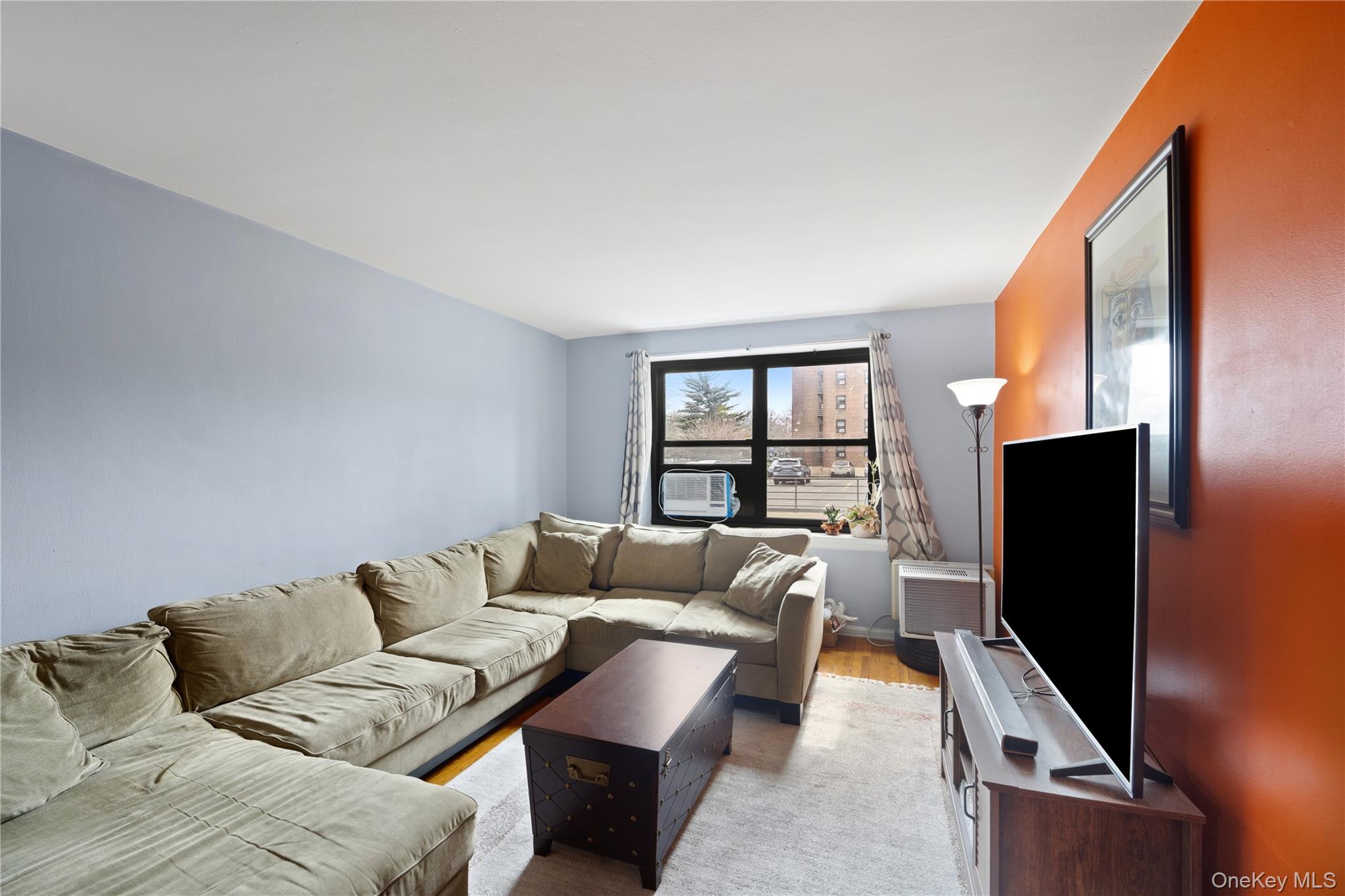 73-11 Bell Boulevard, Unit 2C Queens, NY 11364 - Photo 8 of 16 a living room with furniture and a flat screen tv