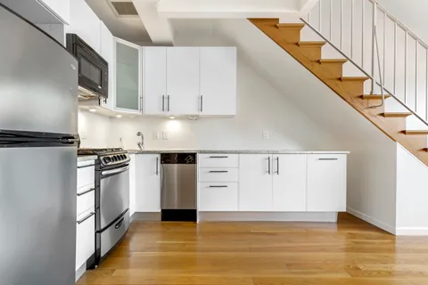 a kitchen with white cabinets and white appliances