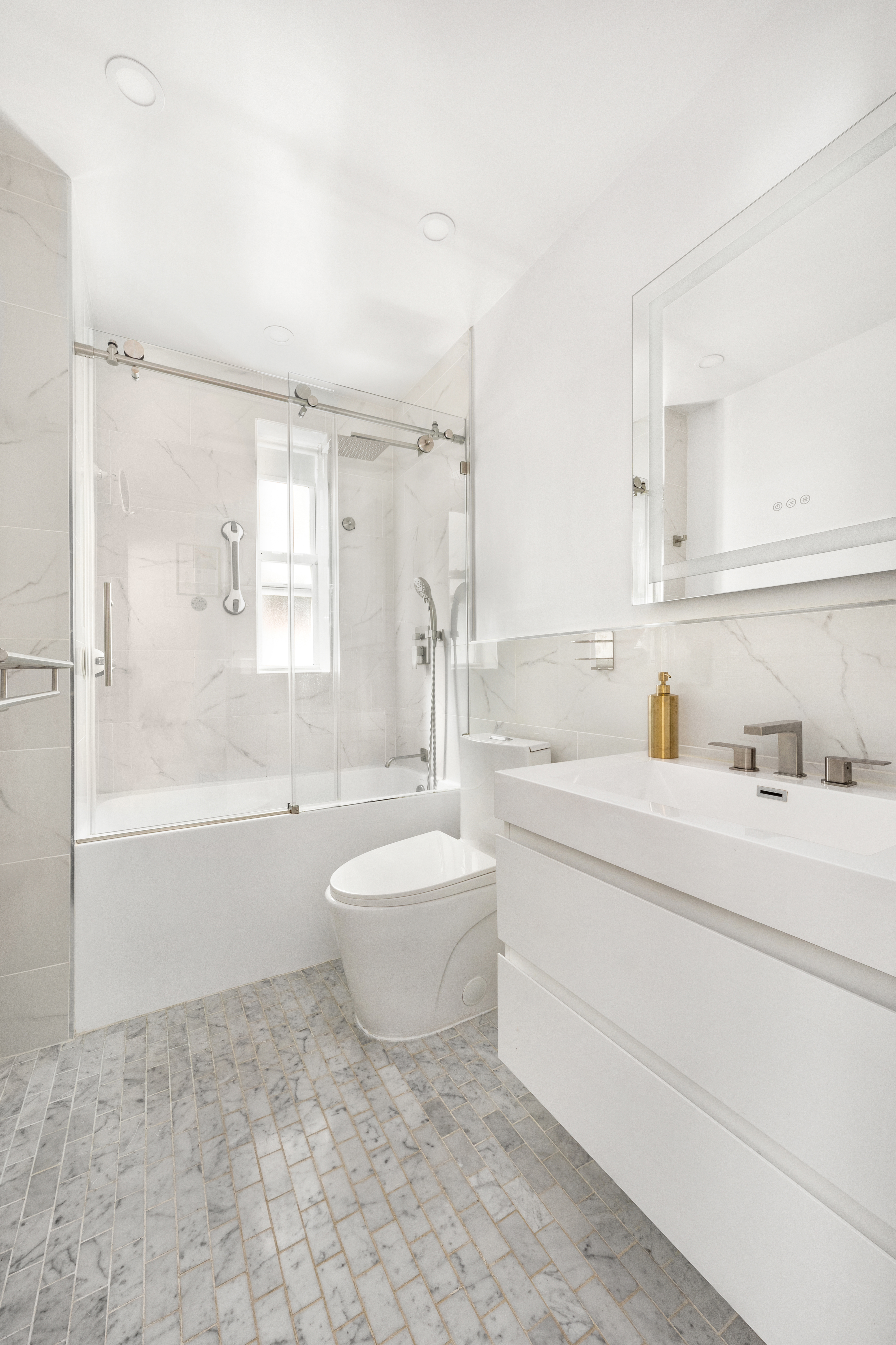 325 East 77th Street, Unit 1E Manhattan, NY 10075 - Photo 6 of 8 a spacious bathroom with a bathtub shower sink mirror and toilet