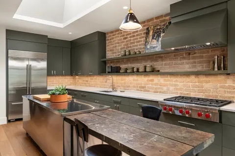 a kitchen with stainless steel appliances kitchen island granite countertop a sink and cabinets